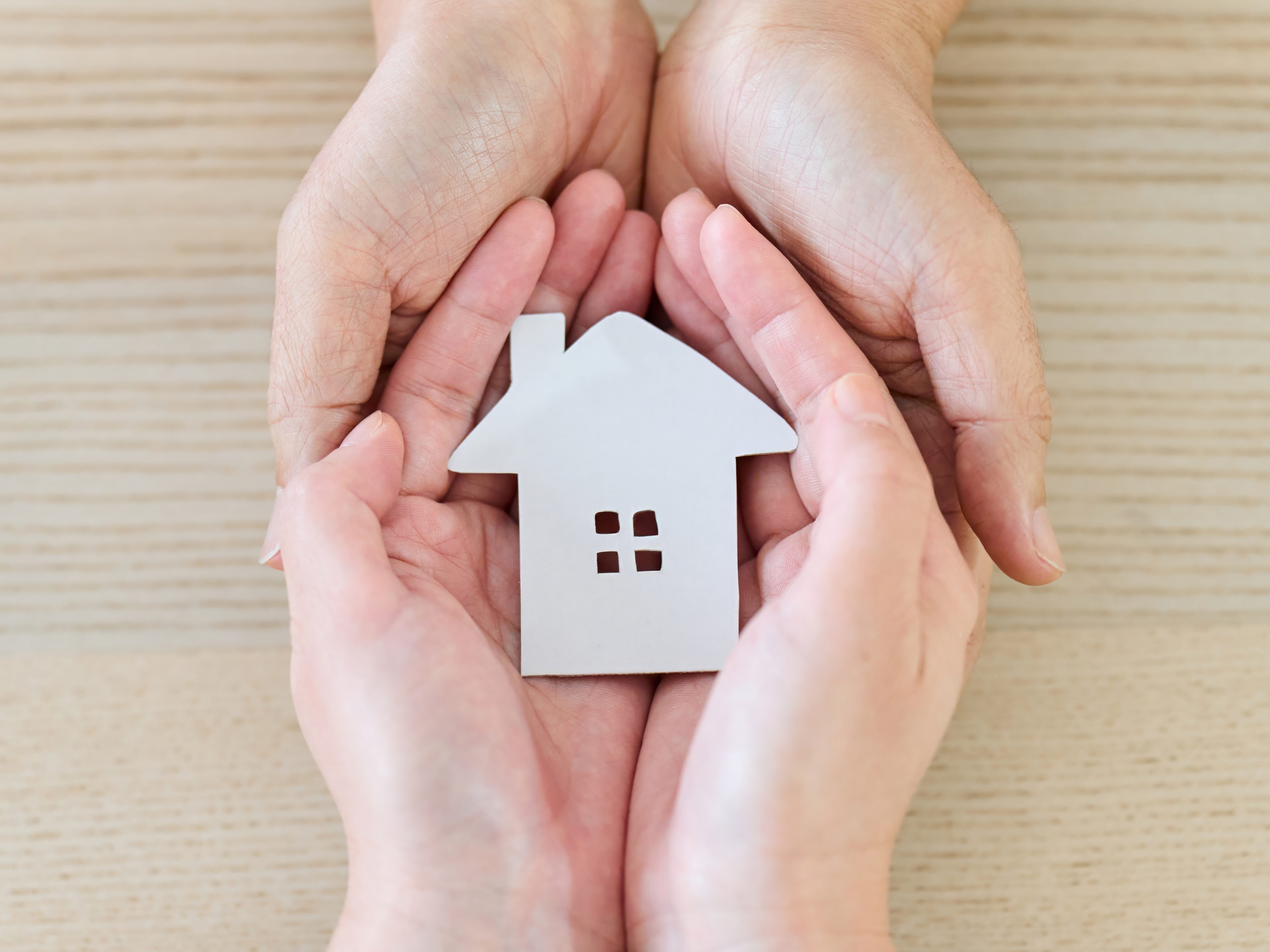 家を包み込む夫婦・カップルの手